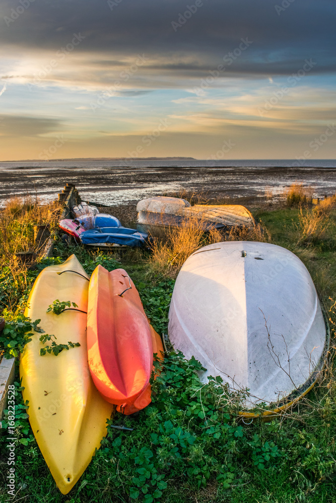 Water sports pleasure boats moored on beach under a winter sunset sky Water sports pleasure boats moored on beach under a winter sunset sky