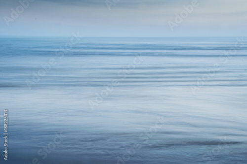 Blue textured background of sea, sand and sky 