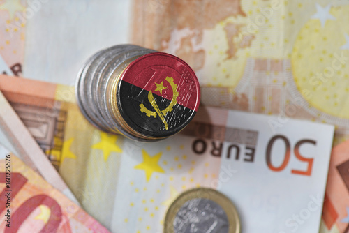 euro coin with national flag of angola on the euro money banknotes background. photo