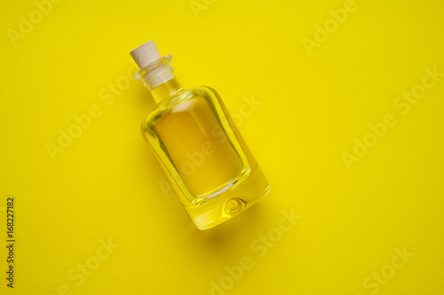 Canvas-taulu Little bottle of sunflower-seed oil on the yellow flat.