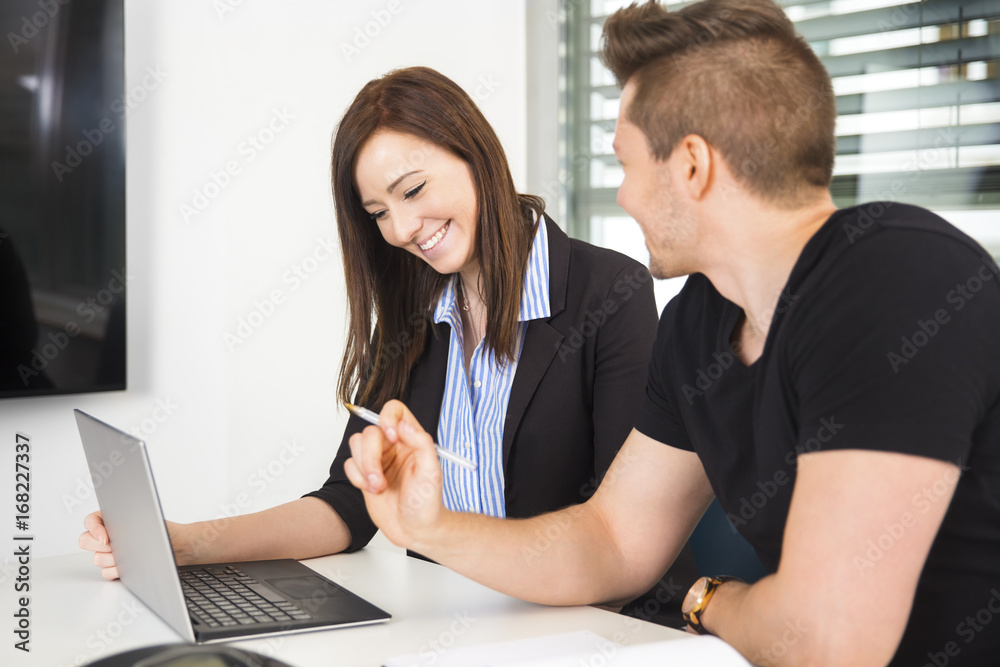 Obraz premium Businesswoman Using Laptop By Colleague At Desk