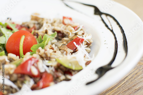 Fragrant Pilau/Pulav / pilaf /pilaf, fried rice with meat and vegetables on a white plate. Isolated on a wooden table.