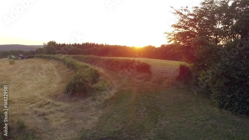 Tractor in a field at sunset