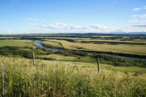 Landscape of the Bow River in Alberta, Canada, during the early summer.  A train track runs next to the river.
