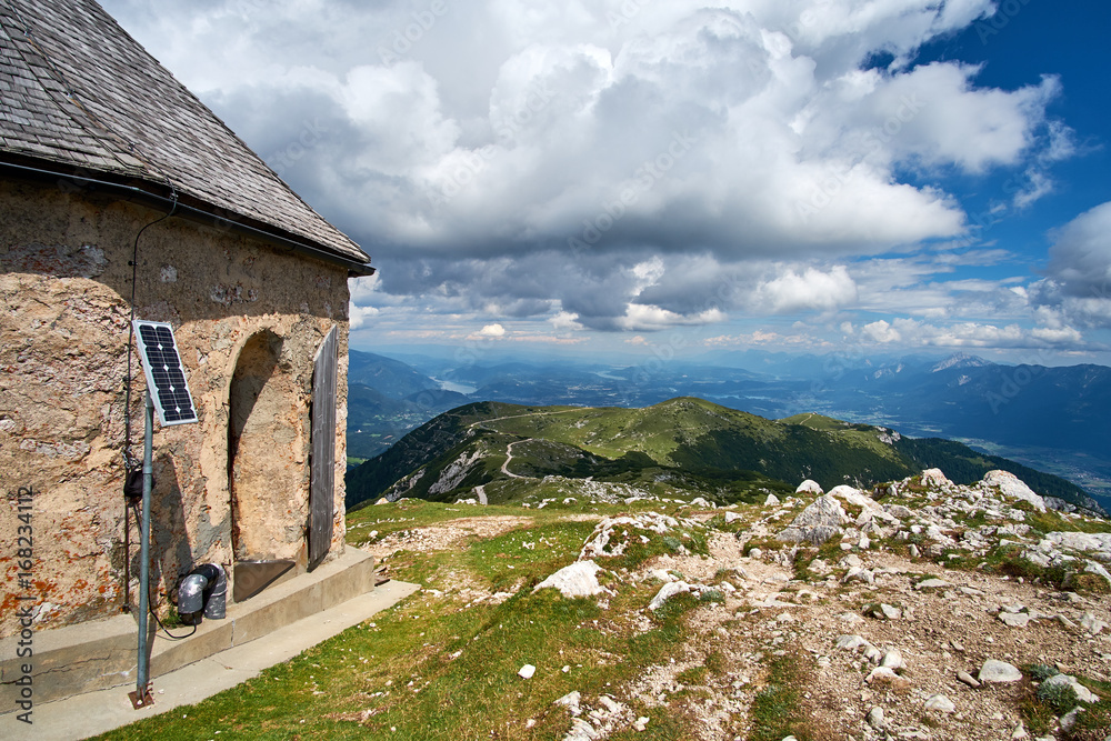Looking out over the Villach area in Austria, from the top of Mt Dobratsch with the german chapel Maria am Stein and a solar panel stand