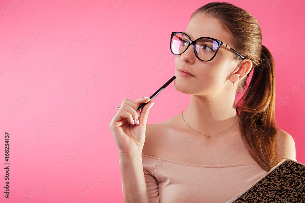 Portrait of a pretty student with a copybook wearing glasses Portrait of a pretty student with a copybook wearing glasses