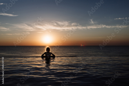silhouette of a girl in the pool, rolling in the sea