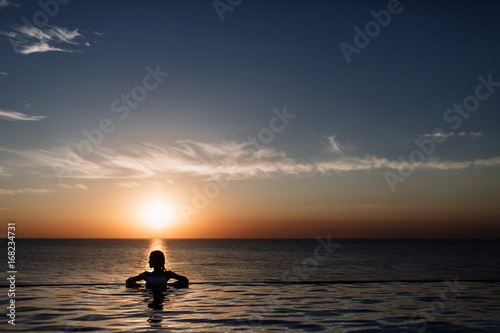 silhouette of a girl in the pool, rolling in the sea © boykovi1991