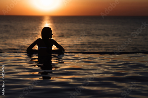 silhouette of a girl in the pool, rolling in the sea