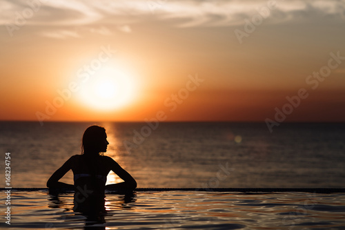 silhouette of a girl in the pool, rolling in the sea © boykovi1991