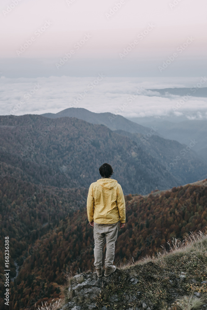 Caucasian man standing in remote mountain landscape Caucasian man standing in remote mountain landscape