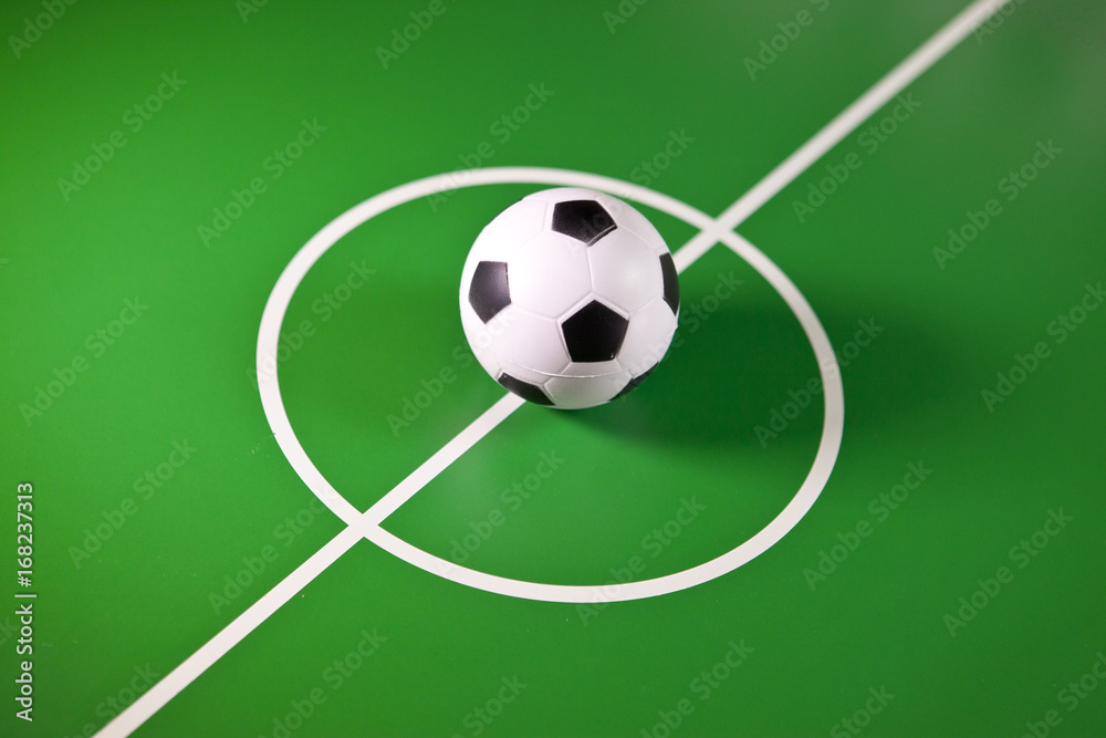 Toy soccer ball in a midfield, in the center of the green field.. Toy soccer ball in a midfield, in the center of the green field..