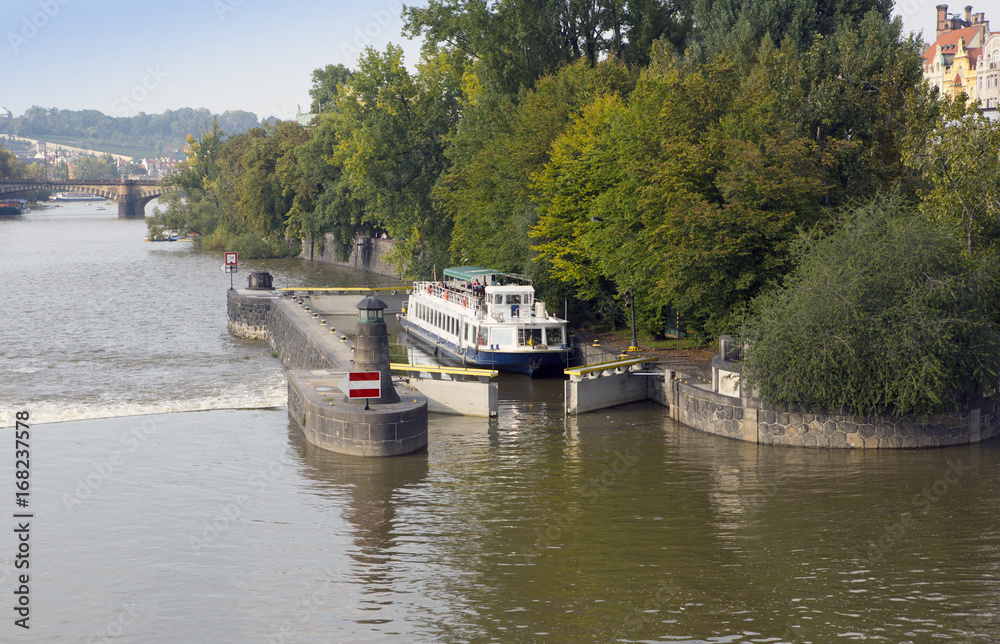 Fototapeta premium walking tourist ship passes a lock on the Vltava River in Prague, Czech Republic...