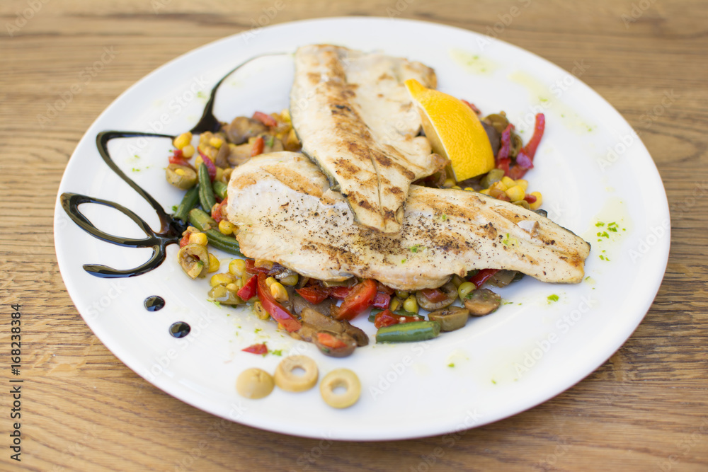 Grill chicken breast. Grilled vegetables with chicken breast. Grilled chicken with vegetables on oak table.