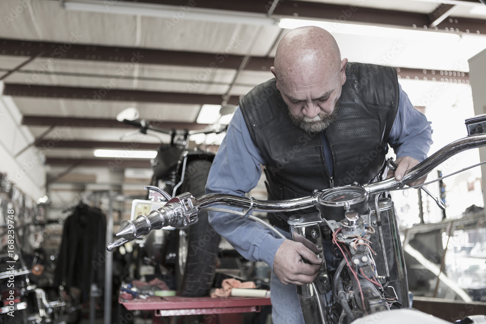 Caucasian man repairing motorcycle Caucasian man repairing motorcycle