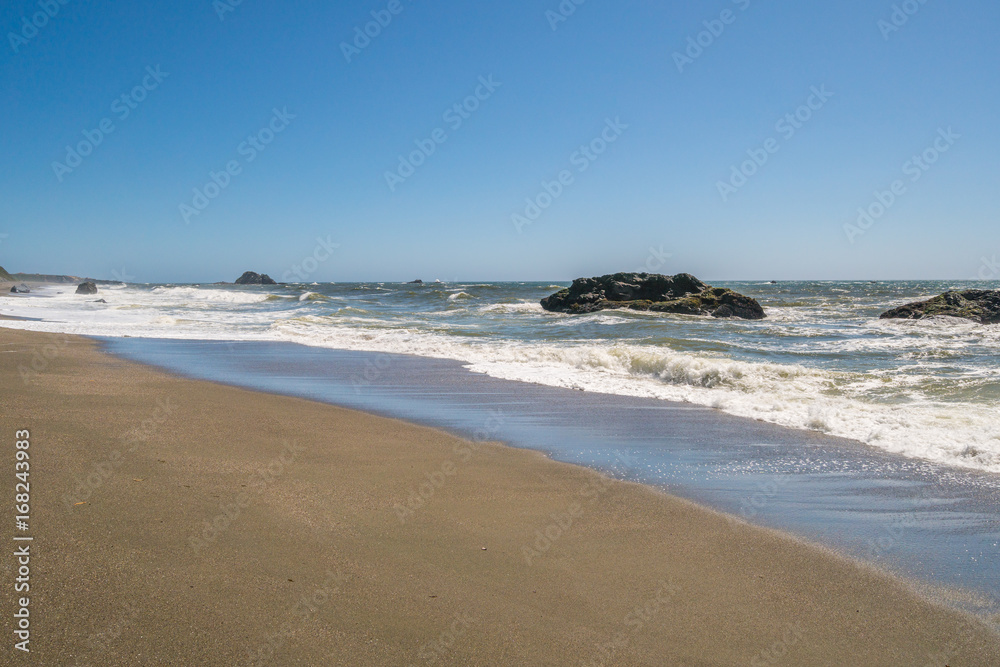 Large boulder among the waves in the sea. Beautiful blue sea. Sonoma Coast State Park, California, USA