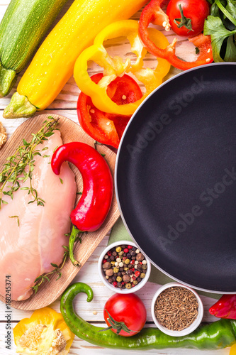 Raw chicken breast fillets with vegetables ingredients in pan