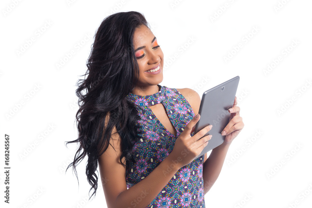 Semi profile of girl using a tablet. Black brazilian girl wearing summer dress.. Semi profile of girl using a tablet. Black brazilian girl wearing summer dress..