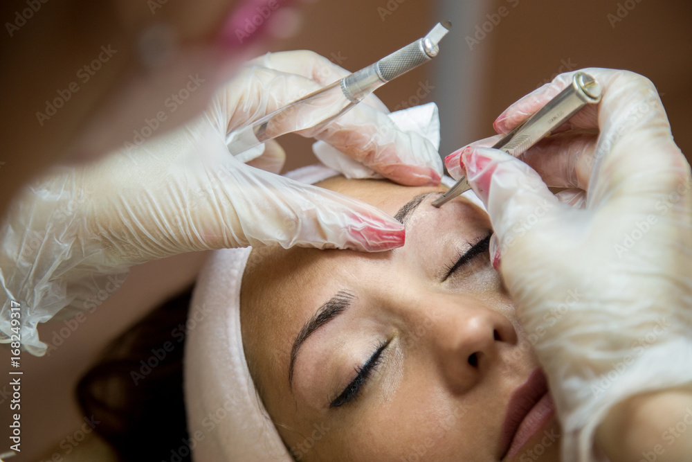 Beautiful woman getting her eyebrows done at a beauty salon Beautiful woman getting her eyebrows done at a beauty salon
