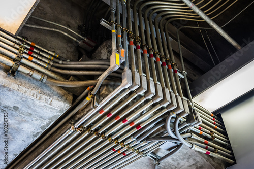 Odd angles of electrical conduits captured in black and white. Taken in an industrial building or architecture.