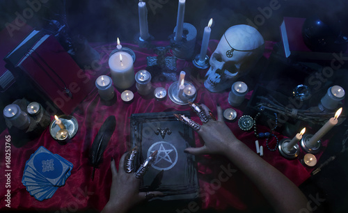 Fotografie, Obraz Witchcraft composition with witch's hands, satanic magic books, skull, candles, tarot cards, crystal and amulets