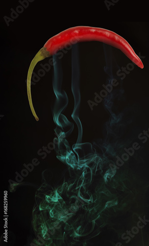 Red hot chili pepper with smoke, on black background.