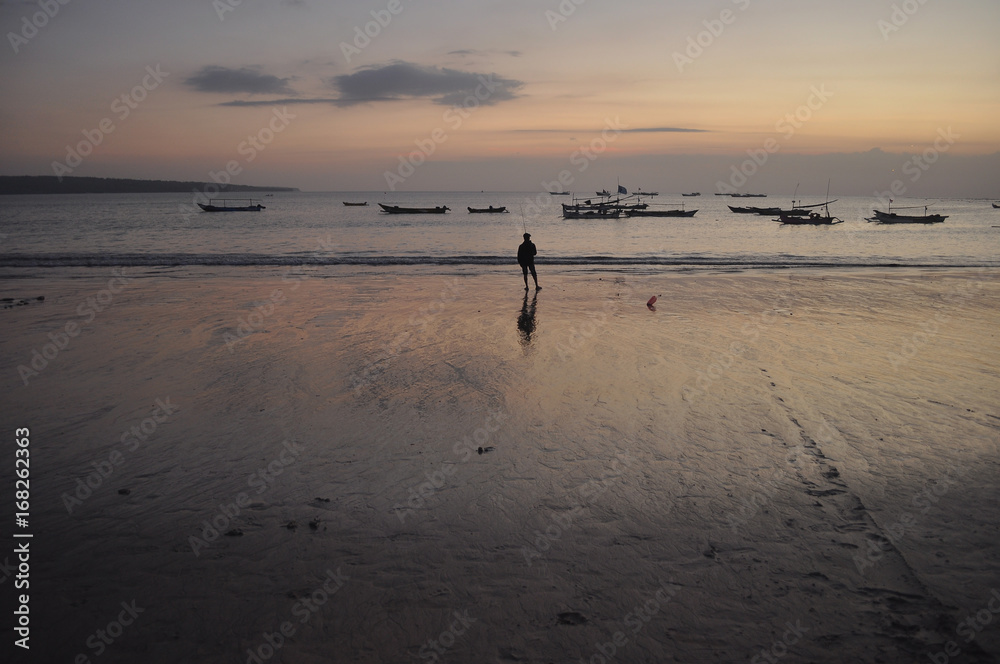 A man standing at the beach on twilight moment