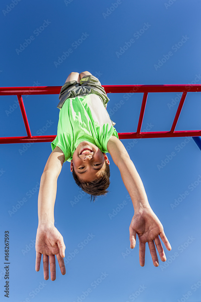 Upside down on the monkey bars. Stock Photo Adobe Stock