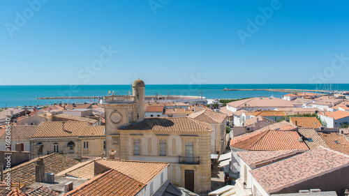      Saintes-Maries-de-la-Mer in Camargue, panorama of the town, tiles roofs, and the sea, view from the church
