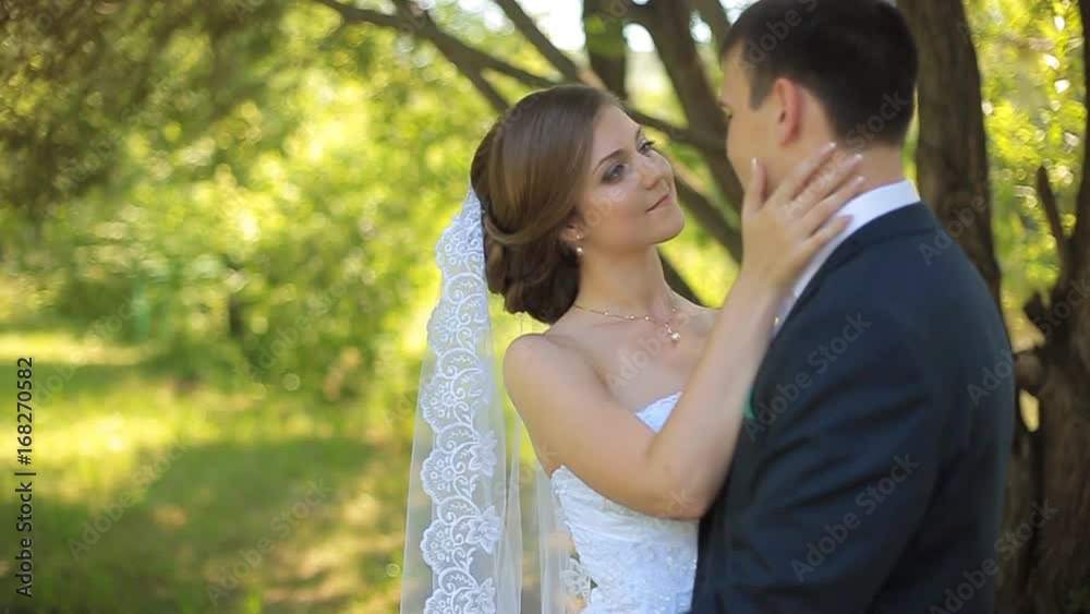 Beautiful bride and groom walking in the park before the wedding ceremony Beautiful bride and groom walking in the park before the wedding ceremony