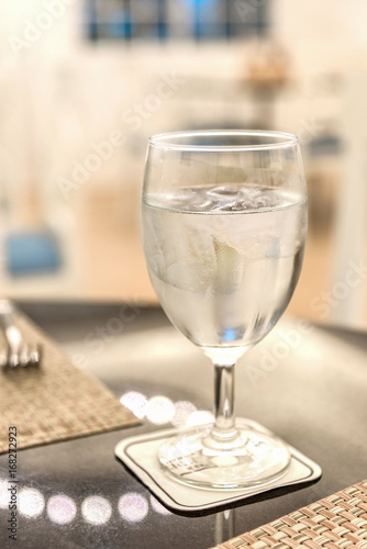 Glass of water with ice on Dining table.