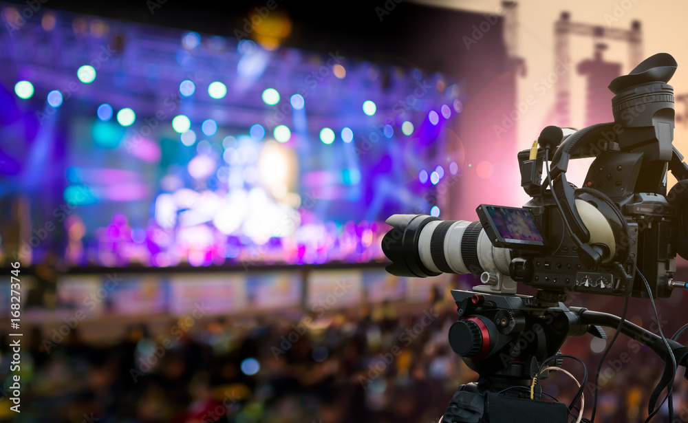 Video production covering event on stage by professional video camera in outdoor concert at sunset - obrazy, fototapety, plakaty 