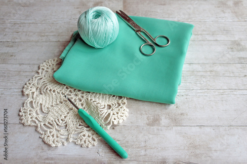 Картината върху платно Fabric and yarn on the table, hook and scissors, materials for a dress