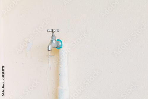 Fotografie faucet color silver - bronze with water drop and old pipe in wall cement backgro