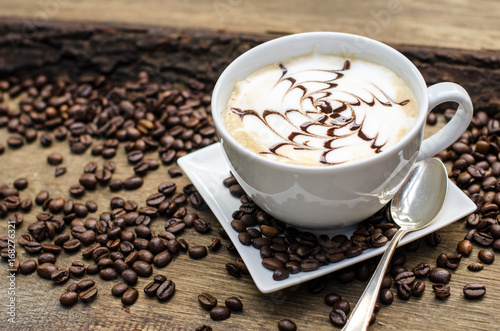 Fototapeta Naklejka Na Ścianę i Meble -  Good Morning: Close up white coffee cup  on wood tab / Cup of latte art coffee with coffee beans :) 