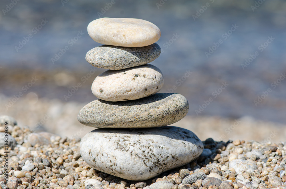 pyramid of colorful pebbles . Rock Zen in the background of the sea. Concept of harmony and balance. pyramid of colorful pebbles . Rock Zen in the background of the sea. Concept of harmony and balance.