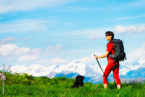 Girl during a mountain hiking trip with her dog