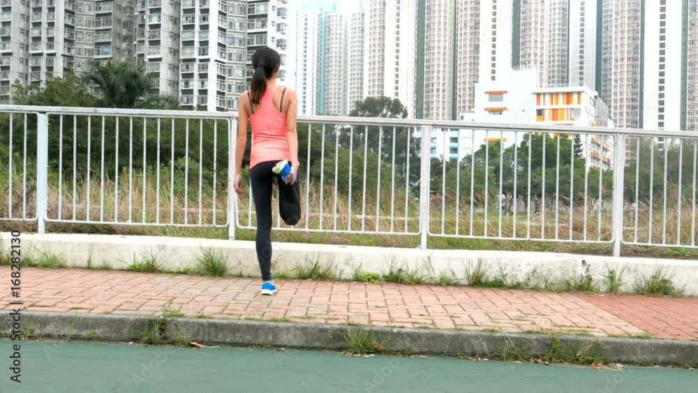 Sportwoman stretching legs before running Sportwoman stretching legs before running