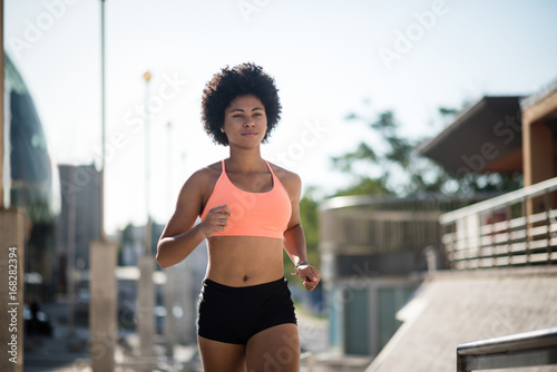 Canvastavla Young woman jogging on a sunny day on city road