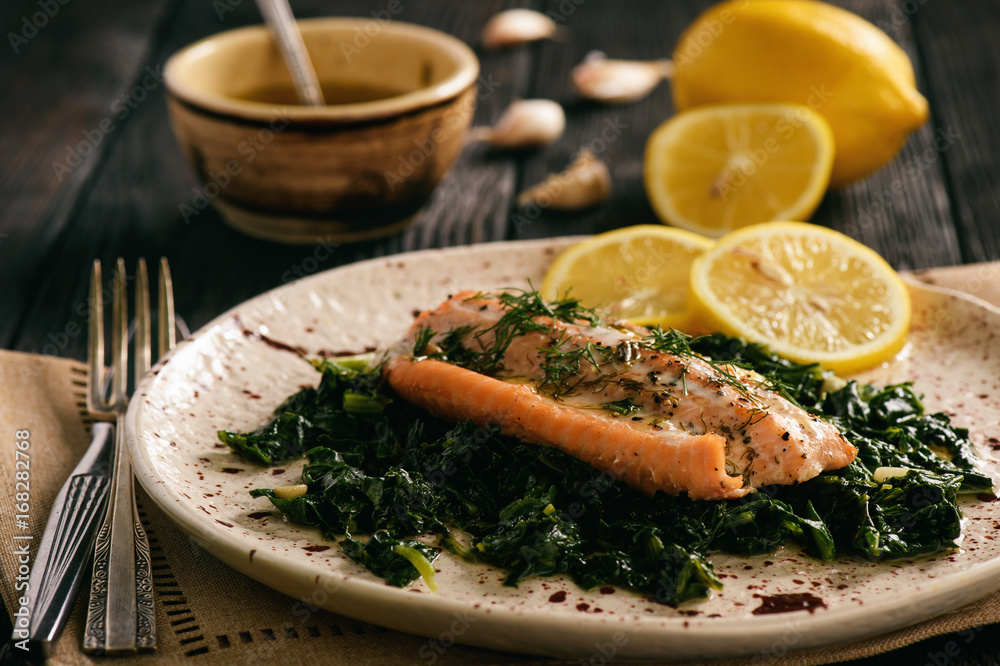 Baked salmon served on stewed spinach with lemon butter sauce.