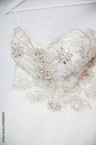 Close-up white wedding dress embroidered with rhinestones, beads, glitter. Corset. Concept engagement, clothes for the bride.