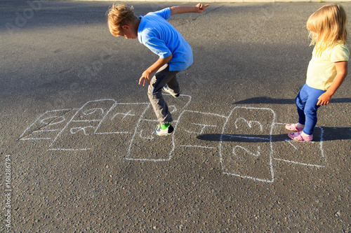 kids playing hopscotch on playground photo