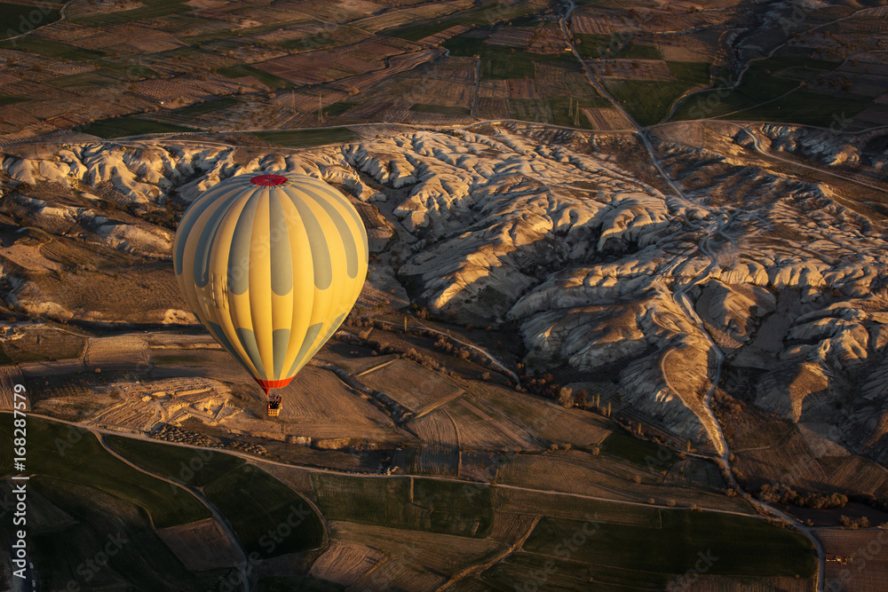 Obraz premium Balloon over Valleys of Cappadocia in background, aerial view