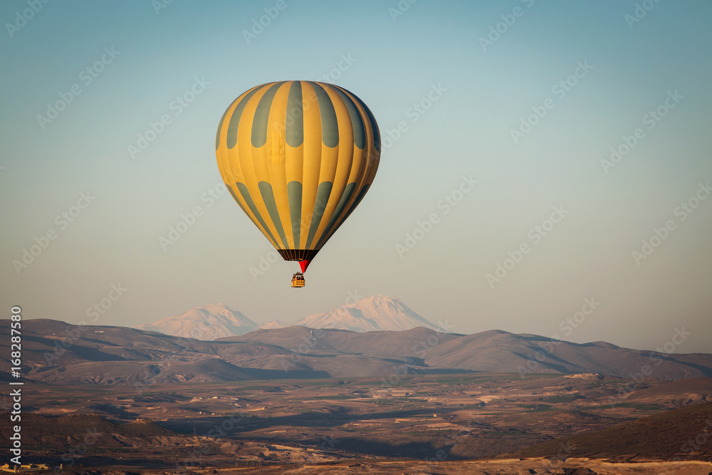 Balloon over Valleys of Cappadocia in background, aerial view