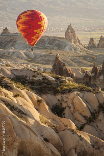 Balloon over Valleys of Cappadocia in background, aerial view