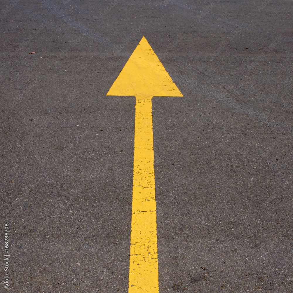 The yellow arrow on the road background The yellow arrow on the road background