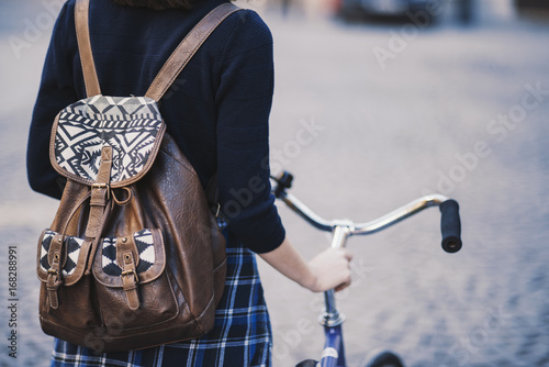 Hipster girl with a bike walking on the street