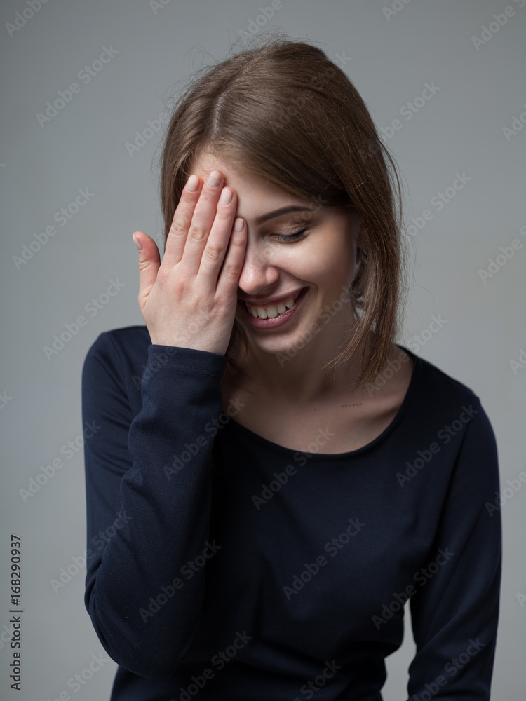 Human positive emotions and feelings. Headshot of cute attractive young European female covering open mouth with hand and closing eyes Human positive emotions and feelings. Headshot of cute attractive young European female covering open mouth with hand and closing eyes