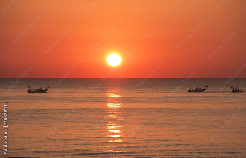 Fishing boats pull their nets at the sunrise. Adriatic cost. Emilia Romagna. Italy Fishing boats pull their nets at the sunrise. Adriatic cost. Emilia Romagna. Italy
