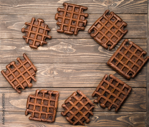 homemade fresh rye waffles in oval shape on wooden background, top view